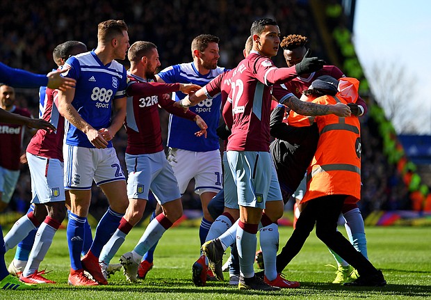 A fan is wrestled to the ground by a steward after punching Aston Villa's Jack Grealish.