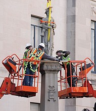 Workers make final preparations before removing a statue of a Confederate soldier from its base in Winston-Salem, N.C., on Tuesday. The statue is to be placed in a historic cemetery.