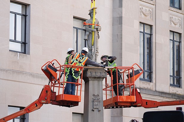 Workers make final preparations before removing a statue of a Confederate soldier from its base in Winston-Salem, N.C., on Tuesday. The statue is to be placed in a historic cemetery.