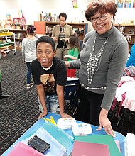 Giving to schools: Fifth-grader Kye’won Williams checks out some of the $1,000 in new school supplies Richmond City Councilwoman Ellen F. Robertson delivered last Thursday to his school, Overby-Sheppard Elementary in North Side, as Principal Kara Lancaster-Gay, in the background, talks with other students. (Jeremy M. Lazarus/Richmond Free Press)