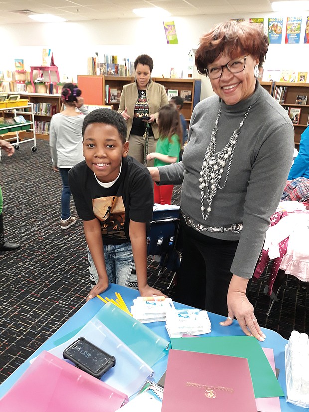 Giving to schools: Fifth-grader Kye’won Williams checks out some of the $1,000 in new school supplies Richmond City Councilwoman Ellen F. Robertson delivered last Thursday to his school, Overby-Sheppard Elementary in North Side, as Principal Kara Lancaster-Gay, in the background, talks with other students. (Jeremy M. Lazarus/Richmond Free Press)