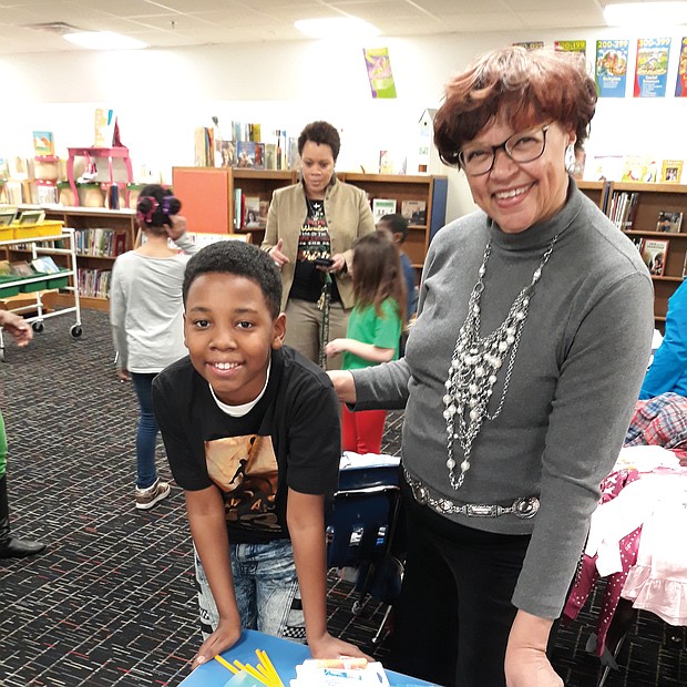 Giving to schools: Fifth-grader Kye’won Williams checks out some of the $1,000 in new school supplies Richmond City Councilwoman Ellen F. Robertson delivered last Thursday to his school, Overby-Sheppard Elementary in North Side, as Principal Kara Lancaster-Gay, in the background, talks with other students. (Jeremy M. Lazarus/Richmond Free Press)
