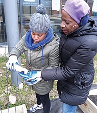 Alia Chambers, co-founder of Sun Path Family Farms, and Sue Roberson plant seeds for peas and green beans Saturday in new beds at Martin Luther King Jr. Middle School in the East End.