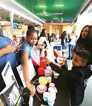 Young entrepreneurs: More than 60 young entrepreneurs who created a variety of products showed off their wares and services during the 2nd Annual Richmond Children’s Business Fair last Saturday at the Children’s Museum of Richmond on West Broad Street near Downtown. Desiayah Dean, 11, of Newport News, second from left, makes and sells her own “slime.” Her creation catches the attention of 7-year-old Chase Fisher Jr. of Richmond, who attended the fair with his parents, Ulani and Chase Fisher. Desiayah’s mother, Rossie Dean, helps her with the sale. (Regina H. Boone/Richmond Free Press)