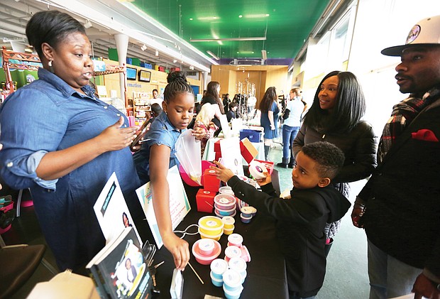 Young entrepreneurs: More than 60 young entrepreneurs who created a variety of products showed off their wares and services during the 2nd Annual Richmond Children’s Business Fair last Saturday at the Children’s Museum of Richmond on West Broad Street near Downtown. Desiayah Dean, 11, of Newport News, second from left, makes and sells her own “slime.” Her creation catches the attention of 7-year-old Chase Fisher Jr. of Richmond, who attended the fair with his parents, Ulani and Chase Fisher. Desiayah’s mother, Rossie Dean, helps her with the sale. (Regina H. Boone/Richmond Free Press)