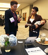 Focus on women’s health: Participants listen to keynote speaker Dr. Faye Belgrave, a health psychology professor and director of the Center for Cultural Experiences in Prevention at Virginia Commonwealth University during last Saturday’s Women’s Health Summit: A Holistic Approach to Women’s Health. The event, sponsored by the Richmond Metropolitan Area Chapter of the National Coalition of 100 Black Women, also featured a panel of women health professionals who addressed topics about mental health. Above, panelist Dr. Micah Allen, a naturopathic doctor and acupuncturist, talks with Demetria Davis and her 4-month-old, Kazi Taylor, during the summit. (Regina H. Boone/Richmond Free Press)