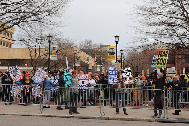 A small group of protesters from Westboro Baptist Church chant and hold signs denigrating the LGBTQ community as a larger group of counterprotesters on the Virginia Commonwealth University campus plays kazoos to drown out their message.