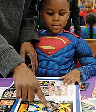 Young Superman/
Jaxson Snowden, aka Young Superman, checks out other superheroes with the help of the greatest superhero of all, his dad, T.J. Snowden, at the Chesterfield Comic Con last Saturday at the Chesterfield County Public Library’s Meadowdale Branch. (Sandra Sellars/Richmond Free Press)