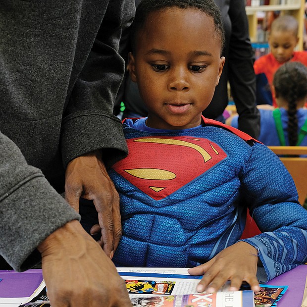 Young Superman/
Jaxson Snowden, aka Young Superman, checks out other superheroes with the help of the greatest superhero of all, his dad, T.J. Snowden, at the Chesterfield Comic Con last Saturday at the Chesterfield County Public Library’s Meadowdale Branch. (Sandra Sellars/Richmond Free Press)