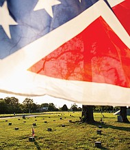 A Confederate battle flag flies over gravesites at the well-maintained Confederate section of Oakwood Cemetery in Richmond. For decades, the state has provided taxpayer money to maintain Confederate graves at the city-owned cemetery.