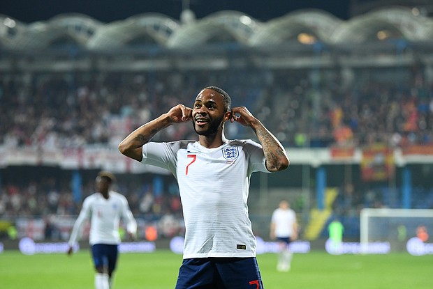 Sterling celebrates by cupping his ears after scoring against Montenegro