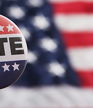 A USA voting pin on an American flag.