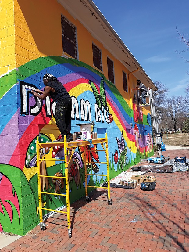 Sir James Thornhill, left, and assistant Michael Rezek put the finishing touches on his “Dream Big” mural that now decorates the Ann Hardy Plaza Community Center in Highland Park in North Side. Best known for the murals he has created in Jackson Ward, Mr. Thornhill was commissioned by the city Department of Parks, Recreation and Community Facilities to create the mural. It adds a bright touch to the park and building which the city has paid more than $1.5 million to renovate and upgrade. The center, named for the late children’s advocate who ran tutoring and preschool programs for years, includes a meeting room, computer lab and a multipurpose space for indoor recreation. (Jeremy M. Lazarus/Richmond Free Press)