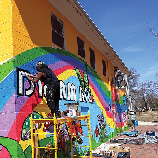 Sir James Thornhill, left, and assistant Michael Rezek put the finishing touches on his “Dream Big” mural that now decorates the Ann Hardy Plaza Community Center in Highland Park in North Side. Best known for the murals he has created in Jackson Ward, Mr. Thornhill was commissioned by the city Department of Parks, Recreation and Community Facilities to create the mural. It adds a bright touch to the park and building which the city has paid more than $1.5 million to renovate and upgrade. The center, named for the late children’s advocate who ran tutoring and preschool programs for years, includes a meeting room, computer lab and a multipurpose space for indoor recreation. (Jeremy M. Lazarus/Richmond Free Press)