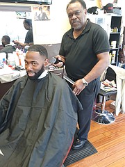 Mr. Barney cuts a customer’s hair in his barbershop in Richmond.