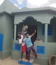 Youths celebrate a new home that Kenneth Barney and his Grace and Mercy Foundation built in Pignon, Haiti.