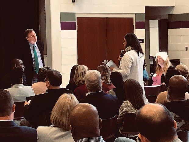 U.S. Sen. Mark Warner, left, listens as a community member speaks at Monday’s town hall-style meeting about food deserts in Richmond and the impact a lack of fresh and healthy foods has in low-income neighborhoods.