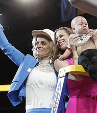 Baylor head coach Kim Mulkey, left, waves the net while standing with daughter and assistant coach Makenzie Fuller and Fuller's son, Kannon Reid Fuller, after winning the national championship over Notre Dame.
