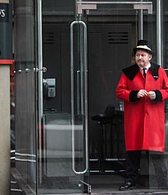 A doorman stands outside the Lloyd's building in London in 2017.