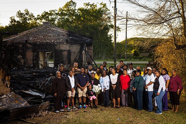 Members of the congregation of Greater Union Baptist Church stand for a portrait in front of the ruins of their former church.