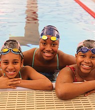 Aquatic dreams: Cherish Daily, left, and T’Mya Harrison, right, sixth-grade and eighth-grade students, respectively, at Richmond’s Franklin Military Academy, pose with Olympic medalist Simone Manuel Tuesday during Splash Day at the newly renovated pool at the Salvation Army Boys & Girls Club in the East End. (Regina H. Boone/Richmond Free Press)