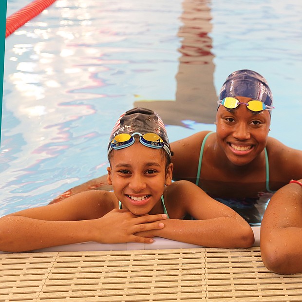 Aquatic dreams: Cherish Daily, left, and T’Mya Harrison, right, sixth-grade and eighth-grade students, respectively, at Richmond’s Franklin Military Academy, pose with Olympic medalist Simone Manuel Tuesday during Splash Day at the newly renovated pool at the Salvation Army Boys & Girls Club in the East End. (Regina H. Boone/Richmond Free Press)