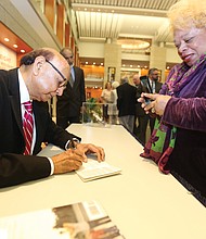 An American story: Khizr Khan of Charlottesville, the father of a U.S. Army captain killed in Iraq in 2004, talked about his new book, “An American Family: A Memoir of Hope and Sacrifice. He appeared April 4 at the Library of Virginia in Downtown as part of the 2019 Carole Weinstein Author Series. He signs a copy of his book for Dr. Paige L. Chargois of Richmond. (Regina H. Boone/Richmond Free Press)