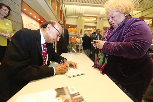 An American story: Khizr Khan of Charlottesville, the father of a U.S. Army captain killed in Iraq in 2004, talked about his new book, “An American Family: A Memoir of Hope and Sacrifice. He appeared April 4 at the Library of Virginia in Downtown as part of the 2019 Carole Weinstein Author Series. He signs a copy of his book for Dr. Paige L. Chargois of Richmond. (Regina H. Boone/Richmond Free Press)