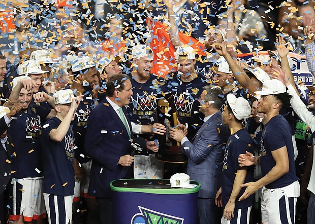 University of Virginia Cavaliers players celebrate their first NCAA Tournament championship win Monday night with Coach Tony Bennett, third from right, on the podium at U.S. Bank Stadium in Minneapolis. The team’s 85-77 victory over Texas Tech came during overtime. It was the first overtime victory in the tournament since 2008 and the eighth in tournament history.