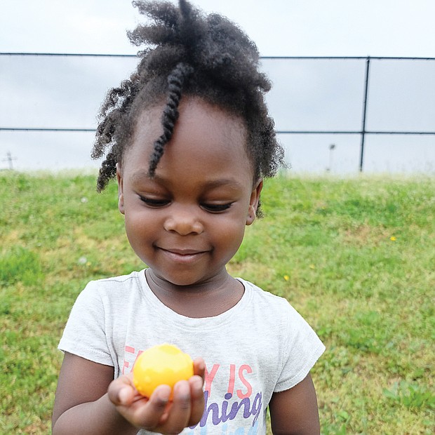 Thrill of the hunt: When it comes to an Easter egg hunt, Zalaya Shaw, 3, is a pro. Not only was the youngster good at finding the colorful treasures, she enjoyed admiring their bright colors. She took part in the 7th Annual Easter Egg Hunt & Celebration sponsored last weekend by Putting Communities Together Inc. (Sandra Sellars/Richmond Free Press)