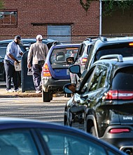 A line of motorists hurry to drop their 2018 federal income tax paperwork in the mail Monday by the tax filing deadline. The anxious drivers, photographed here about 6 p.m. Monday at the Main Post Office on Brook Road, were trying to ensure their envelopes received an April 15 postmark to avoid being hit with a penalty for missing the deadline. (Sandra Sellars/Richmond Free Press)