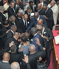 Dr. William Eric Jackson Sr. speaks from the pulpit Sunday at Fourth Baptist Church in Church Hill following his installation as the ninth pastor of the historic church that traces its beginnings to 1859. Visiting ministers and church deacons participate in a “laying of hands” ceremony with Dr. Jackson, seated, to cap the ceremony. (Ava Reaves)