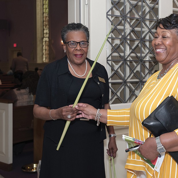Palm Sunday: Leola Hill, left, lead usher at St. Paul’s Baptist Church Belt Boulevard campus in South Side, hands Edna Austin a palm at the 10 a.m. worship service April 14 on Palm Sunday. The Christian feast day, held the Sunday before Easter, commemorates Jesus’ entry into Jerusalem just days before his crucifixion and resurrection. According to the Gospels, Jesus rode into Jerusalem on a donkey, where people celebrating him as the son of God laid palm fronds, small branches and clothing in his path. (Ava Reaves)