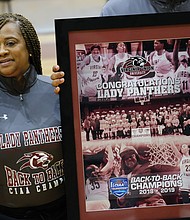 VUU Athletic Jamboree
Virginia Union University Lady Panthers Coach AnnMarie Gilbert and her basketball team members receive a congratulatory poster for winning back-to-back CIAA Tournament championships in 2018 and 2019. The recognition came last Saturday during the university’s annual Athletic Jamboree that included a double-header for the VUU softball team and the Panthers football team’s annual spring football game. Right, former longtime VUU football Coach Willard Bailey greets people from the bleachers. (Sandra Sellars/Richmond Free Press)
