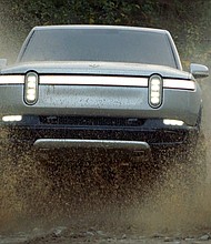Ford is investing $500 million in electric pickup truck maker Rivian, saying the two companies will work together to develop a new battery for plug-in vehicles.
