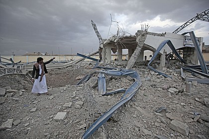 Yemeni man inspects a destroyed petrol station after it was targeted by Saudi-led airstrikes