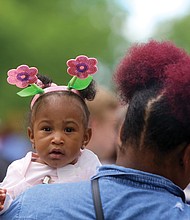 Easter on Parade: Six-month-old Maryiah Tims looks over the shoulder of her aunt, Zaire Tims, during Sunday’s Easter on Parade event along Monument Avenue. Like Maryiah, hundreds of people dressed in holiday finery and bonnets for the annual free event. The future of Easter on Parade is up in the air as sponsor Venture Richmond backs out. (Regina H. Boone/Richmond Free Press)