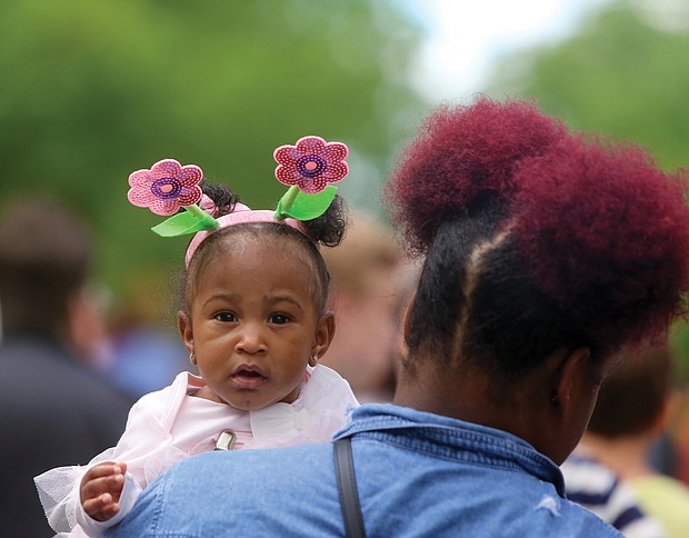 Easter on Parade: Six-month-old Maryiah Tims looks over the shoulder of her aunt, Zaire Tims, during Sunday’s Easter on Parade event along Monument Avenue. Like Maryiah, hundreds of people dressed in holiday finery and bonnets for the annual free event. The future of Easter on Parade is up in the air as sponsor Venture Richmond backs out. (Regina H. Boone/Richmond Free Press)