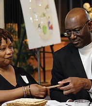 People from many different faiths and backgrounds participate in an interfaith Passover “Justice Seder” Monday evening, using the Exodus story and Passover rituals to shine a light on modern-day oppression of racism, sexism, militarism and materialism. The event was held at Temple Beth-El on Grove Avenue. Above, Giselle Johnson and Tony Lamb break a piece of matzah during the Seder. (Sandra Sellars/Richmond Free Press)