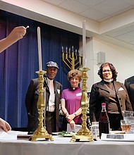 People from many different faiths and backgrounds participate in an interfaith Passover “Justice Seder” Monday evening, using the Exodus story and Passover rituals to shine a light on modern-day oppression of racism, sexism, militarism and materialism. The event was held at Temple Beth-El on Grove Avenue. Above, Miriam Aniel of Richmond Jews for Justice conducts the candle lighting as other faith leaders look on. (Sandra Sellars/Richmond Free Press)