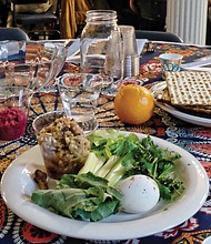 People from many different faiths and backgrounds participate in an interfaith Passover “Justice Seder” Monday evening, using the Exodus story and Passover rituals to shine a light on modern-day oppression of racism, sexism, militarism and materialism. The event was held at Temple Beth-El on Grove Avenue. A ritual meal, displayed above, was shared at each table during the Passover celebration. (Sandra Sellars/Richmond Free Press)