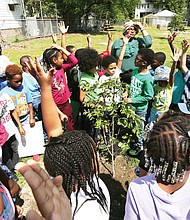 Planting for the future: Students from North Side’s Barack Obama Elementary School plant a young dogwood tree with the help of Luke McCall, a Dominion Energy forester, on April 23, just a few days before Arbor Day. The first-graders in Kerry Richardson, Liz Pearson and Carla Lewis’ classes have been studying the importance of trees as part of a free environmental education program developed by the utility company that is now in its 13th year. (Regina H. Boone/Richmond Free Press)