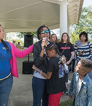 Young Zy’Asia Jordan cries in the arms of her grandmother, Valencia Harris, as Ms. Harris talks about her missing daughter, Unique Harris. Families shared stories about their missing loved ones last Saturday during the 3rd Annual Richmond Missing Persons Day Rally at Chimborazo Park. At left is Toni Jacobs, organizer of the event, whose daughter Keeshae, was last seen on Sept. 26, 2016. Ms. Harris’ grandson, Zy’Kei, looks on, along with, from rear left to right, Pamela Rogowski and her twin, Lisa Sullivan of Spotsylvania and Monique Smith who have missing family members. (Ava Reaves)