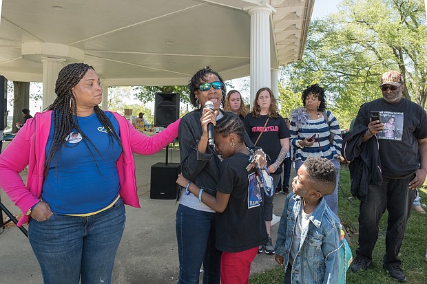 Young Zy’Asia Jordan cries in the arms of her grandmother, Valencia Harris, as Ms. Harris talks about her missing daughter, Unique Harris. Families shared stories about their missing loved ones last Saturday during the 3rd Annual Richmond Missing Persons Day Rally at Chimborazo Park. At left is Toni Jacobs, organizer of the event, whose daughter Keeshae, was last seen on Sept. 26, 2016. Ms. Harris’ grandson, Zy’Kei, looks on, along with, from rear left to right, Pamela Rogowski and her twin, Lisa Sullivan of Spotsylvania and Monique Smith who have missing family members. (Ava Reaves)