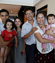 Wa Lone poses with his wife Pan Ei Mon and daughter, along with fellow reporter, Kyaw Soe Oo, carrying his daughter, next to wife Chit Su Win.