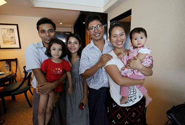 Wa Lone poses with his wife Pan Ei Mon and daughter, along with fellow reporter, Kyaw Soe Oo, carrying his daughter, next to wife Chit Su Win.