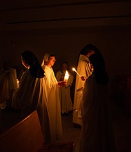 Nuns and guests at Our Lady of the Angels light candles during Easter Vigil Mass at the monastery in Crozet.