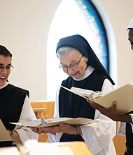 From left, Sister Maria Gonzalo, Sister Barbara Smickel and Sister Myriam Saint-Vilus take a break from cheese making to practice a song for Palm Sunday Mass.