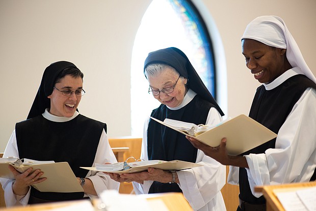 From left, Sister Maria Gonzalo, Sister Barbara Smickel and Sister Myriam Saint-Vilus take a break from cheese making to practice a song for Palm Sunday Mass.