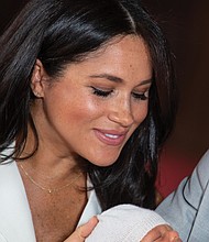 Archie Harrison Mountbatten-Windsor, or Master Archie as he will be known, has his first media moment Wednesday as he is held tightly in the arms of his dad, Prince Harry.